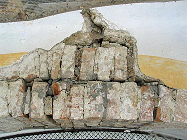 Risse im Mauerwerk hinter einem Seitenaltar